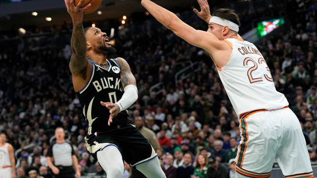 Dec 19, 2023; Milwaukee, Wisconsin, USA; Milwaukee Bucks guard Damian Lillard (0) shoots around San Antonio Spurs center Zach Collins (23) during the first quarter at Fiserv Forum.
